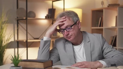 Mature Man Studying with Books Indoors