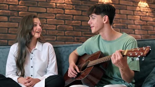 Teen Boy Playing Guitar and Singing for Friend