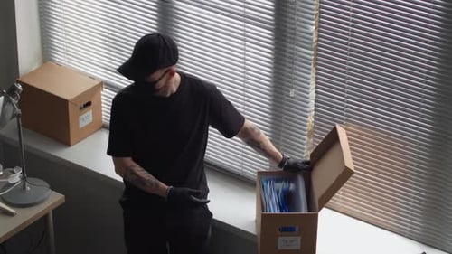 Männlicher Dieb hackt sich in den Bürocomputer, während der Partner nach geheimen Dateien sucht