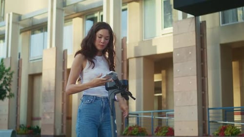 Beautiful Brunette Woman Scanning Code Renting Scooter on City Street Summer Day