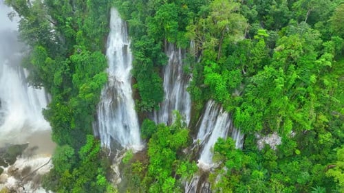Breathtaking waterfall in lush green jungle from drone.