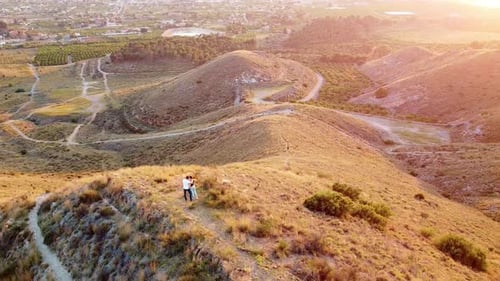 young couple hiking through mountains at sunset drone view point. Dron aerial view at sunset in Mur