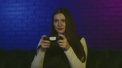 Woman Playing Video Game With Controller At Home