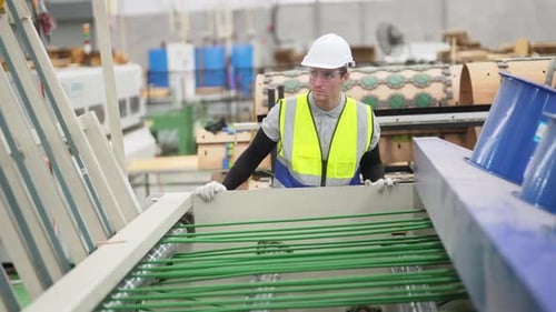 young engineer looking in the machine and check conveyer feeding belt of machine.