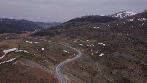 Vista aérea con un Zumbido de una carretera asfaltada entre montañas nevadas en la Turquía rural