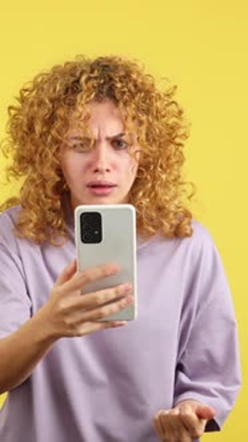 Worried Woman with Curly Hair Using a Mobile