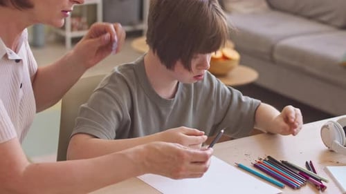 Woman and Child Drawing Together at Table