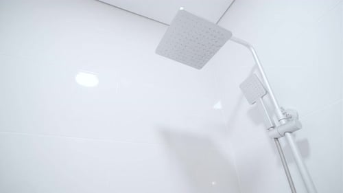 Modern rain shower faucet design. Bathroom. White tiles on the wall. Stylish bright bathroom