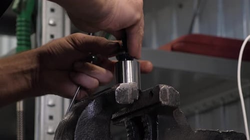A Mechanic Disassembling a Piston at a Service Station Engine Repair