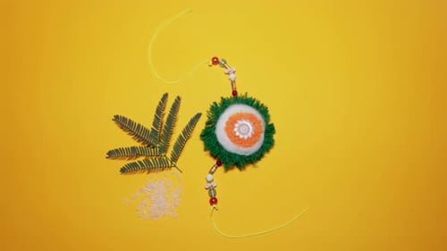 colorful handmade rakhi with decorative threads and festive yellow background