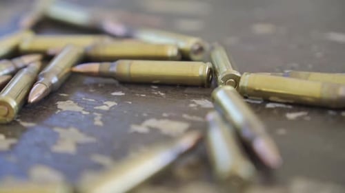 Geschosse auf dem Boden, vorbeifahrende Reihen von M-16-Kanonenmunition. Militärische Munition vor dem Abflug