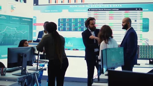 Team Discussing Stock Data on Large Digital Display