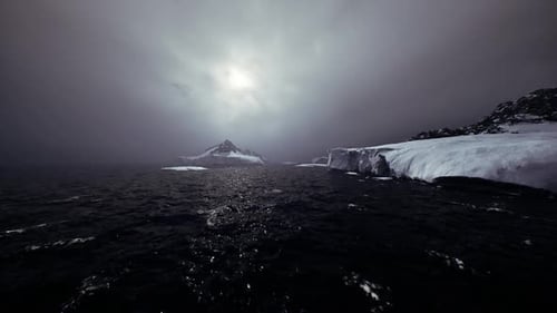 Dark Wintry Ocean Water with Snow Covered Coastline