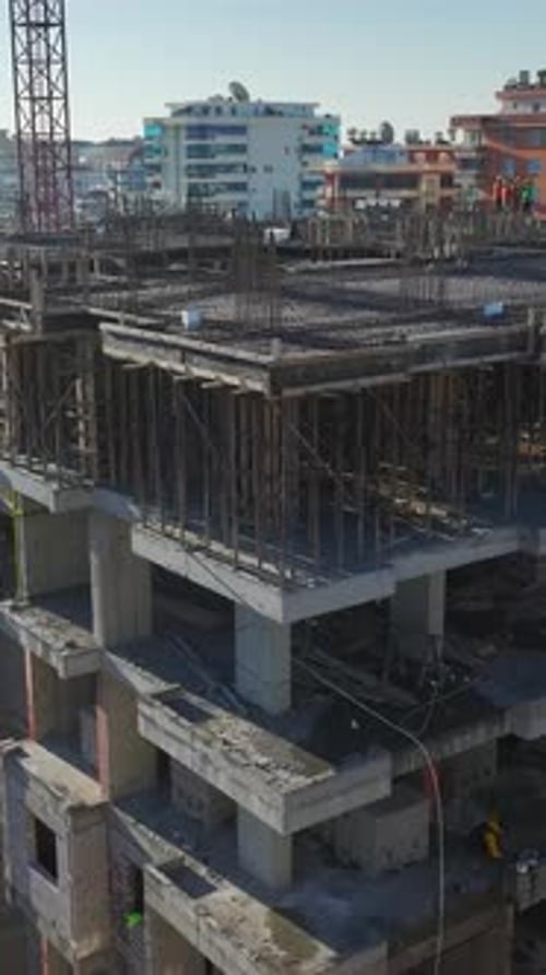 Vertical Video of Residential Construction With Workers Installing Metal Beams and a Crane Assisting