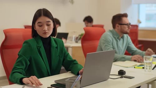 Portrait d'une jeune femme d'affaires confiante, directrice assise au bureau, travaillant à taper sur un ordinateur portable