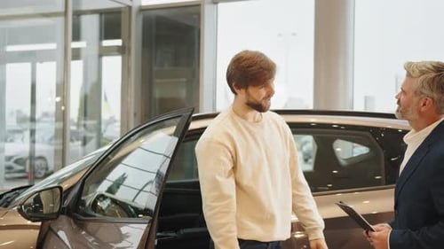 Young Man Buys Car at Dealership