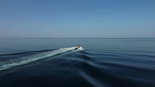 Aerial Woman on Wakeboard Young Athlete Riding Wakesurf Behind Boat Towing Wave Drone Shot of a Girl