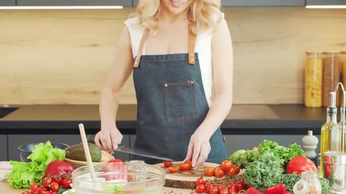 Woman Prepares Colorful Salad in Bright Kitchen