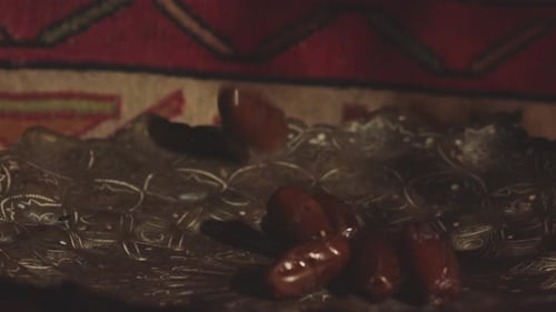 Delicious dried dates roll in a dish. Close up slow motion shot.