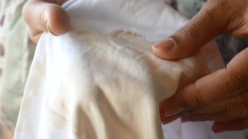 Hands Holding Stained White Cloth