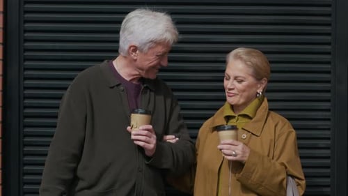 Modern Senior Couple Drinking Coffee Outdoors