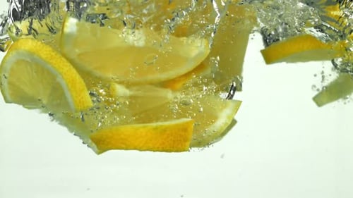 Lemon Slices Falling Into Water Tank