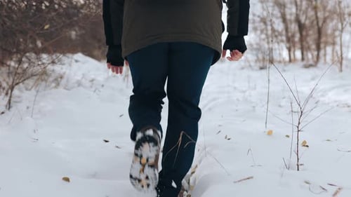 Close Up of a Lone Traveler Legs Gracefully Navigating the Winter Wonderland