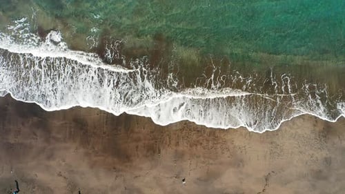 Vue aérienne de haut en bas sur la plage de sable volcanique noir