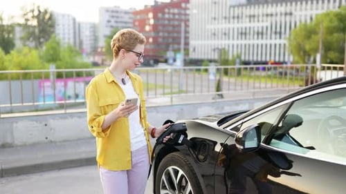 Woman with Short Hair Charges Electric Car