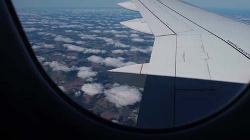Eine faszinierende Luftaufnahme einer wunderschönen bewölkten Landschaft, die während des Fluges aus einem Flugzeugfenster gesehen wurde