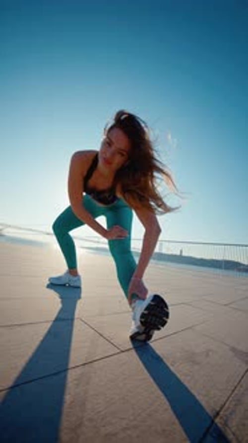 Woman Stretching Leg Outside on Sunny Day