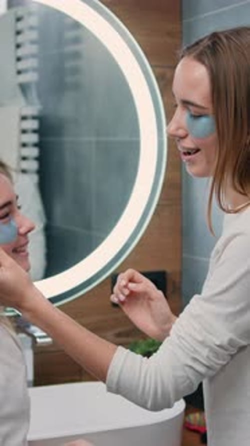 Woman Applying Eye Patches to Child in Bathroom