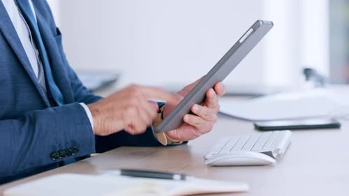 Adult In Suit Using Tablet at Desk