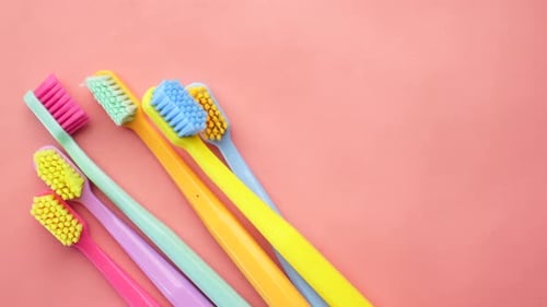 Colorful Toothbrushes on a Light Pink Background