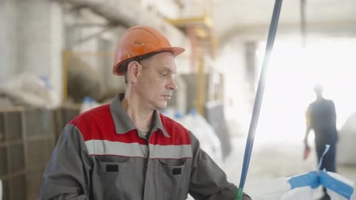 Industrial Worker in Safety Gear Operating a Crane Hook of Cathead Crane