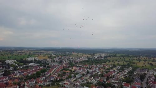 Red and white balloons are flying over the German city, aerial shot, 4k