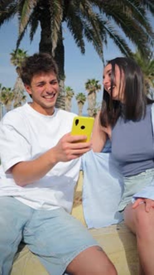 Joyful Young Couple Taking a Memorable Selfie Together with a Smartphone in a Beautiful Park Setting