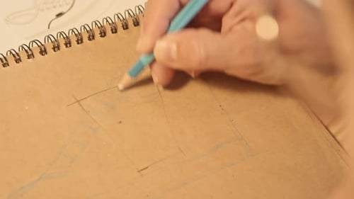 Hand Draws Shoe Design in Notebook