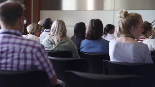 Attendees seated in a corporate conference, viewed from behind