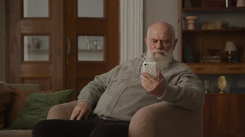 Älterer Mann mit schlechtem Sehvermögen benutzt Smartphone
