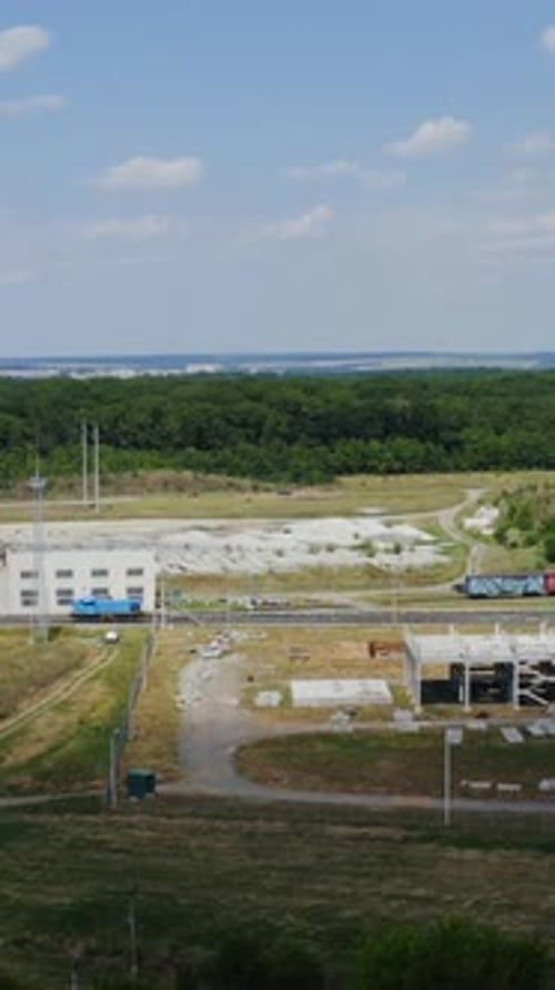 Zona industrial com trem de carga em uma ferrovia. Movimento do trem de carga sobre fundo verde da natureza.