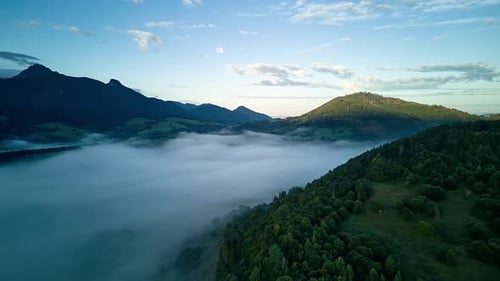 Aerial Time Lapse of Thick Morning Mist Flowing Through Mountain Valley