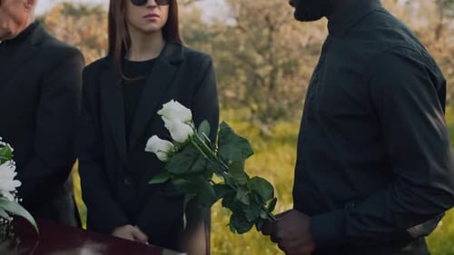 Mourners Stand Beside Casket at Outdoor Funeral