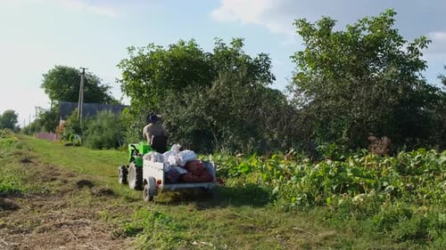 Man Driving Small Tractor in Rural Setting