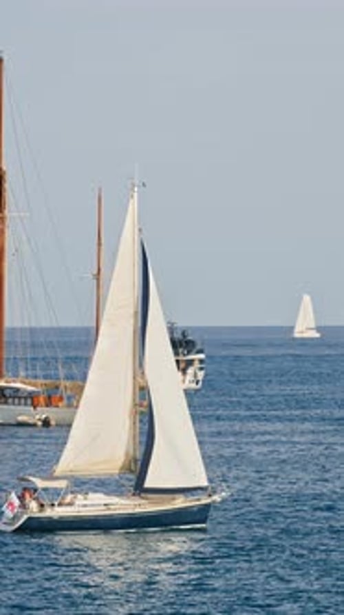 White boats moving on the sea in Antibes, France. Vertical