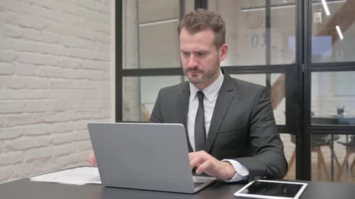 Man in Suit Stressed at Office Desk