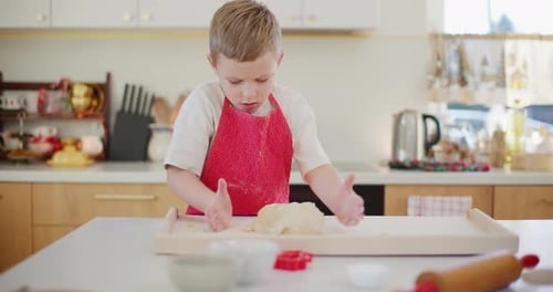 Boy Kneading Bread Dough In The Kitchen