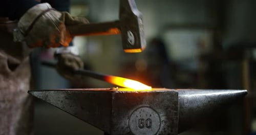 Blacksmith Forging Hot Metal on Anvil with Hammer