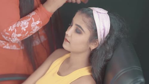 Makeup Artist Applying Cosmetics to Young Woman