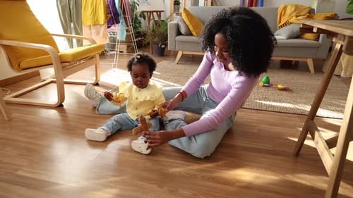 Mutter und Kind spielen mit Spielzeugtieren auf dem Boden
